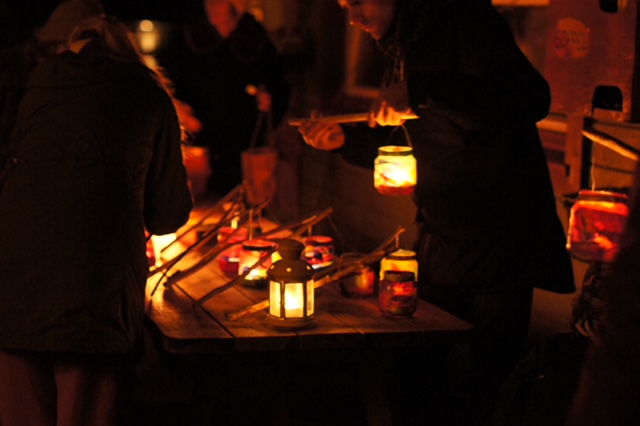 Folk rundt bord med tente lanterner